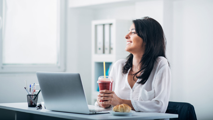 SVP-Netzwerktreffen am 28. November von 9-15 Uhr. © ©Suteren Studio - stock.adobe.com, AK Stmk Frau sitzt am Schreibtisch, hält einen Smoothie in der Hand und lacht. Vor ihr steht der Laptop und daneben ein Croissant. © ©Suteren Studio - stock.adobe.com, AK Stmk