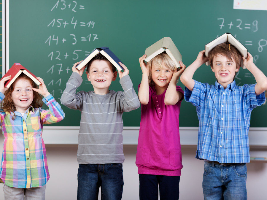 Kinder vor der Tafel mit Büchern am Kopf © fotolia/contrastwerkstatt, AK Stmk