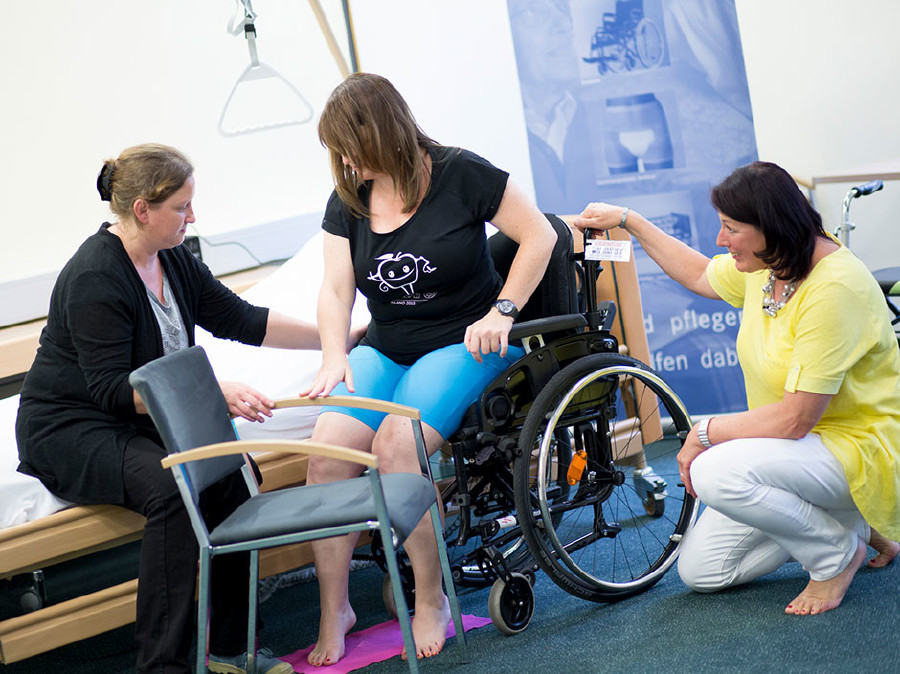 Auf der Pflegemesse wird das richtige Heben aus dem Rollstuhl gezeigt. © Graf, AK Stmk