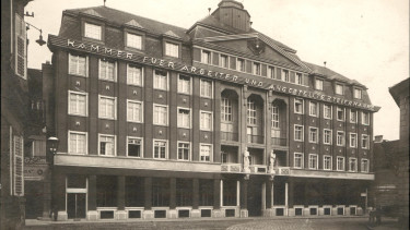 Ansicht des AK-Gebäudes aus dem Jahr 1927. Im Zweiten Weltkrieg wurde das Haus schwer beschädigt. Später wurde es wieder auf- und umgebaut.