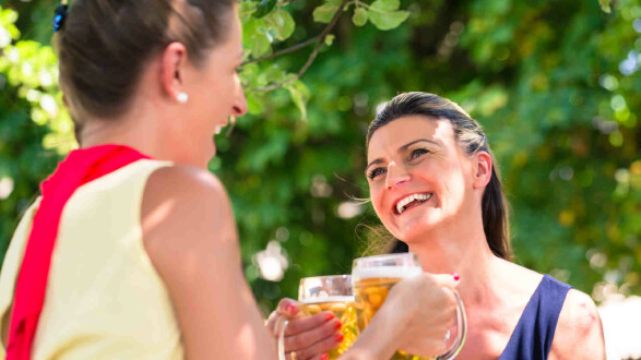 Zwei Frauen mit Bierkrügen im Gastgarten