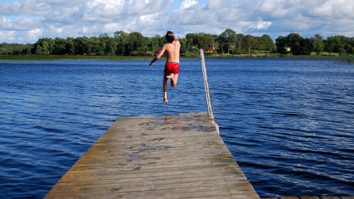 Ein Junge springt in einen See
