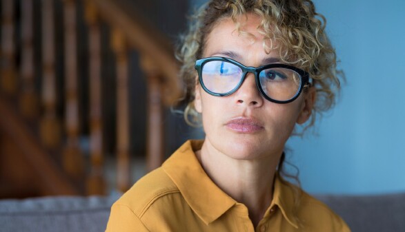 Nahaufnahme des Gesichts einer nachdenklichen Frau mit Brille