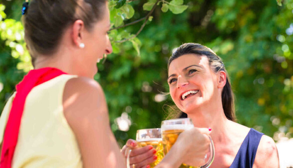 Zwei Frauen mit Bierkrügen im Gastgarten