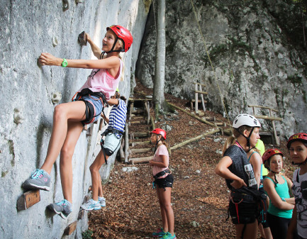 Kinder klettern an einer Felswand. © kuume, Ferienhort