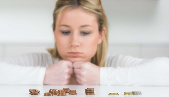 Frau mit traurigem Blick auf Geldmünzen © Picture-Factory, stock.adobe.com